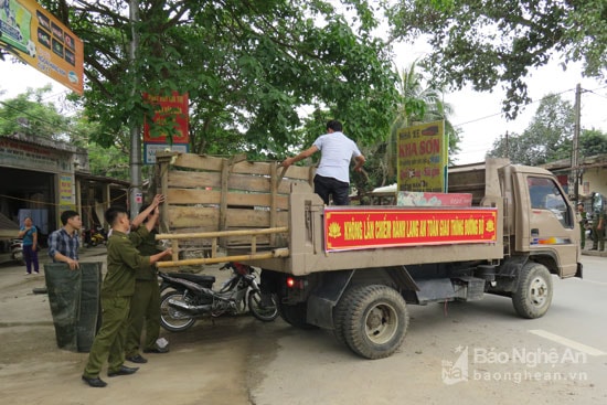 Cưỡng chế, thu giữ các sạp để hàng những hộ dân cố tình vi phạm, không tuân thủ quy định. Ảnh: Bé Vinh