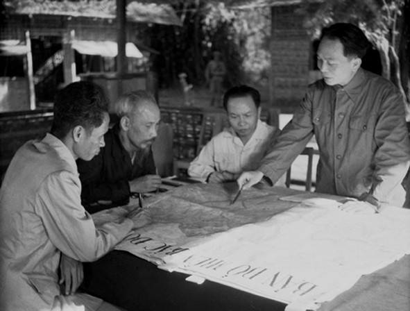 Đại tướng Võ Nguyên Giáp (đứng, bên phải) trình bày với Chủ tịch Hồ Chí Minh và các đồng chí lãnh đạo Đảng, Nhà nước bàn kế hoạch mở chiến dịch Điện Biên Phủ năm 1954. Ảnh: Tư liệu TTXVN.