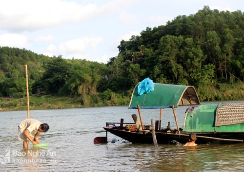 Nhiều khi nguy hiểm bắt đầu từ sự chủ quan của người lớn. Trong ảnh: Một người bố ở làng chài lo mải mê với công việc để con nhỏ tự vui chơi với sông nước. Ảnh: Huy Thư
