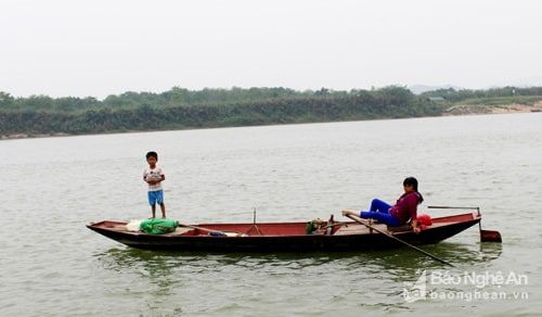 Nhiều gia đình cho con xuống các thuyền nhỏ cùng đi làm trên sông. Các cháu vô tư đứng trước mũi thuyền trong sự bất cẩn của người lớn. Ảnh: Huy Thư