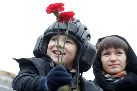 Em bé cầm hoa trong lễ duyệt binh Ngày Chiến thắng ở Moscow. Ảnh: Reuters