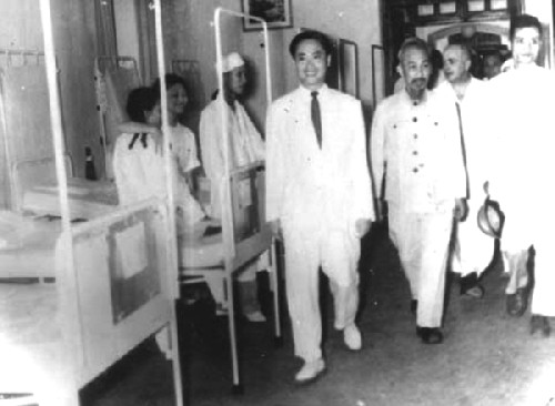 GS.Tôn Thất Tùng (người mặc complet trắng bên trái) dẫn Chủ tịch Hồ Chí Minh thăm Bệnh viện Việt - Đức sau ngày Hà Nội giải phóng (10/10/1954)