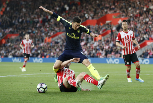 Ozil đi bóng trước sự truy cản của cầu thủ Southampton. Ảnh: Reuters.