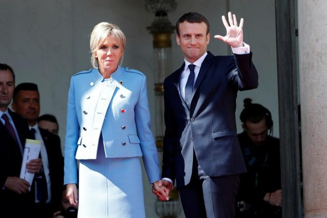 Tổng thống Pháp Emmanuel Macron cùng vợ là Brigitte Trogneux vẫy tay tại buổi lễ ở Điện Elysee, Paris, Pháp hôm 14/5. Ảnh: Reuters