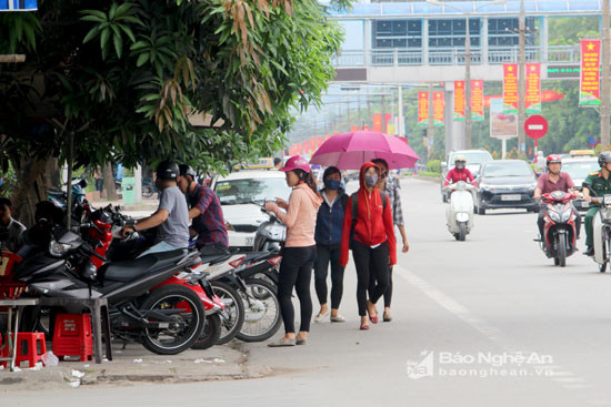 Chính sự lấn chiếm vỉa hè của nhiều hộ kinh doanh đã đẩy người đi bộ xuống lòng đường. Ảnh chụp trước cổng Đại học Vinh, đường Nguyễn Du. Ảnh: Nguyên Nguyên