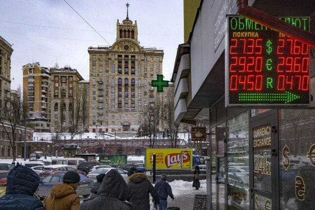 Người đi bộ đi ngang qua một biển báo tỷ giá ngoại tệ bên ngoài một điểm giao dịch ở thủ đô Kiev, Ukraine. Những biến động về tỷ giá xuất hiện nhiều trong nhiệm kỳ của thổng thống Valeriya Gontareva (Bloomberg)