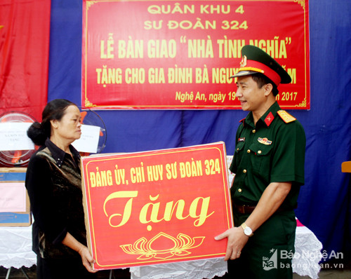 Đồng chí Thượng tá Đoàn Xuân Bường - Phó chính ủy Sư đoàn tặng quà cho bà Nguyễn Thị Năm. Ảnh: Hà Hữu Tân