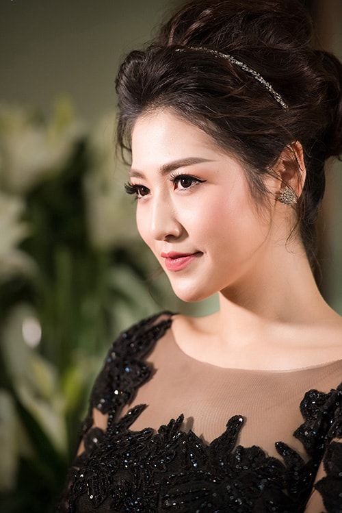 Á hậu Tú Anh trang điểm theo tông hồng nhẹ, búi tóc phồng.
