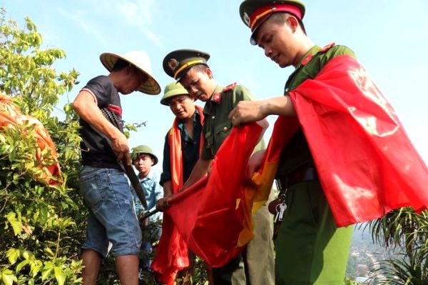  Cán bộ, chiến sỹ công an huyện Anh Sơn thay cờ trên đỉnh lèn Vũ cao 300 m tại thôn 9 xã Tường Sơn. Ảnh: Huyền Trang