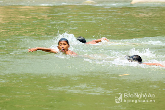 Một số trẻ em khác tìm niềm vui trên khe suối bằng cách tổ chức các cuộc thi bơi lội. Đây là trò chơi không kém phần mạo hiểm vì nguy cơ đuối nước xảy ra rất cao nhưng nhiều trẻ vẫn tỏ ra thích thú vì không có sân chơi nào khác. Ảnh: Đào Thọ