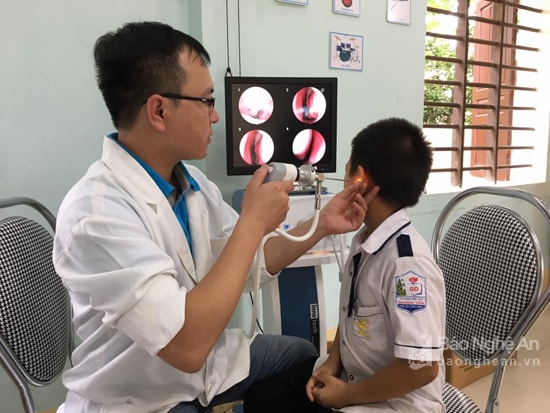 Bác sĩ chuyên khoa Tai mũi họng, Bệnh viện Quốc tế Vinh khám tầm soát các bệnh về tai mũi họng cho học sinh trường TH Hòa Hiếu 2. Ảnh: Đinh Nguyệt