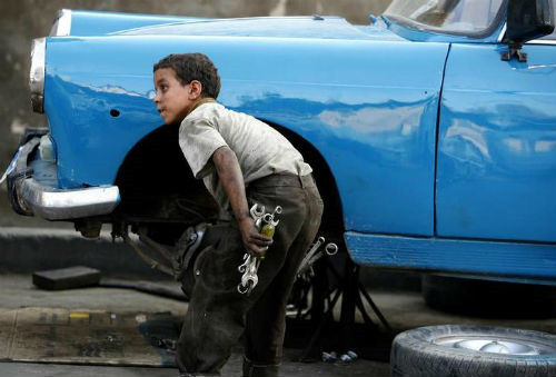 Một cậu bé người Ai Cập đang sửa xe.  Ảnh: Reuters