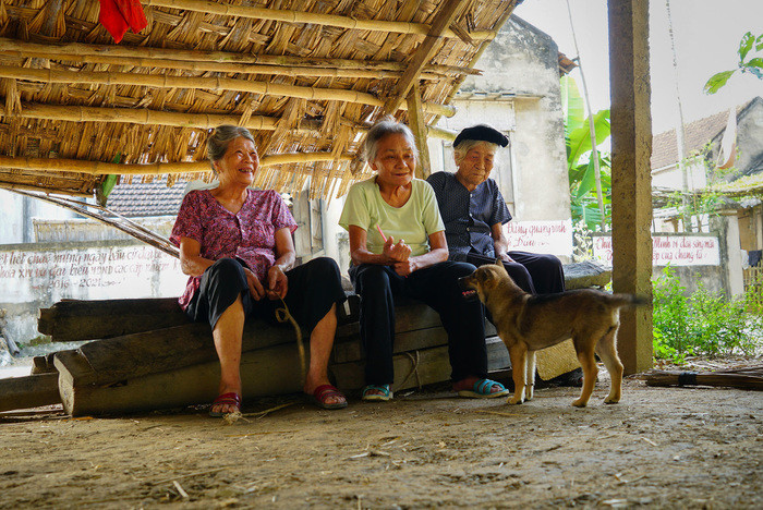 Các cụ già trong làng vẫn thường xuyên ra chỗ đan liếp vừa xem con cháu làm việc, vừa kể lại kỷ niệm thời trẻ của mình. Ảnh: Hồ Chiến