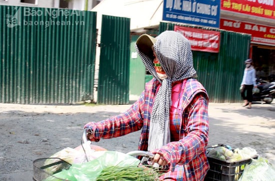 Người phụ nữ này vẫn tranh thủ bịt kín đi rao bán hết lô hàng đã nhập từ sáng sớm. Ảnh: Phương Thúy