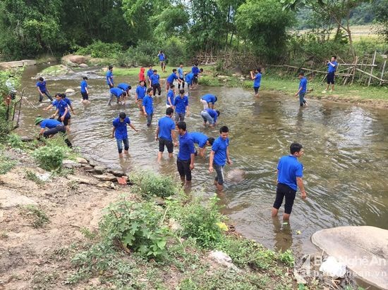 Các đoàn viên thanh niên tham gia dọn vệ sinh điểm du lịch khe Cớ. Ảnh: Đình Tuân