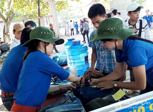 Các tình nguyện viên hướng dẫn thủ tục cho các thí sinh tham dự kỳ thi vào lớp 10 THPT năm 2017-2018. Ảnh: Sỹ Bắc