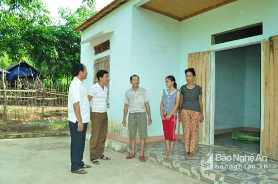 Cán bộ UB Mặt trận Tổ quốc xã Nghĩa Trung và lãnh đạo xóm 13, Đồng Cạn đến động viên, thăm hỏi hoàn cảnh gia đình cháu Yến. Phía sau là ngôi nhà do xã và huyện hỗ trợ xây dựng cho chị Hà Thị Ngọ và con gái. Ảnh: Nguyễn Hải