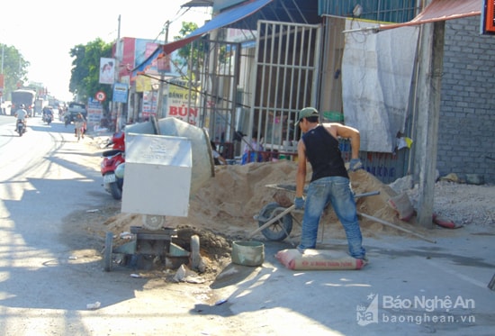 Không chỉ lấn chiếm vỉa hè, có hộ gia đình còn đổ vật liệt xây dựng xuống cả lòng đường gây nguy hiểm giao thông. Ảnh: Thanh Toàn