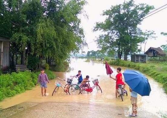 Những đứa trẻ ở bản Hoa Tiến - Châu Tiến (Quỳ Châu) chơi đùa trong mưa. Ảnh: Hữu Vi