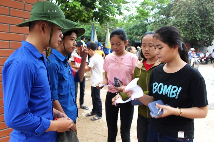 Kiểm tra thẻ dự thi và dụng cụ học tập của thí sinh trước lúc vào trường. Ảnh: Huy Thư