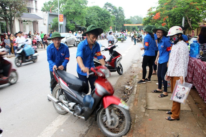 Hướng dẫn và giúp đỡ các phụ huynh cất, gửi xe đúng chỗ. Ảnh: Huy Thư