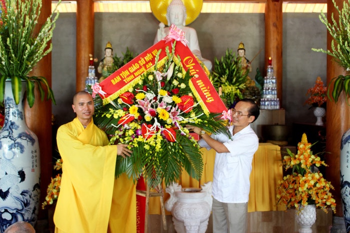 Ông Lưu Công Vinh - Phó Giám đốc Sở Nội vụ tặng hoa chúc mừng nhà chùa. Ảnh: Huy Thư