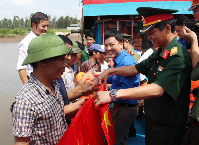 Tỉnh Đoàn, Bộ chỉ huy Quân sự tỉnh và đoàn công tác trao tặng ngư dân xã Sơn Hải 500 lá cờ Tổ quốc tại tàu của ngư dân Hoàng Đình Phương. Ảnh: Hoài Thu