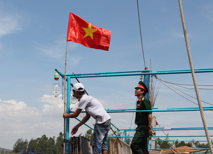 Người dân xã Sơn Hải hãnh diện treo cờ Tổ quốc chuẩn bị cho chuyến vươn khơi bám biển, đánh bắt hải sản. Ảnh: Hoài Thu