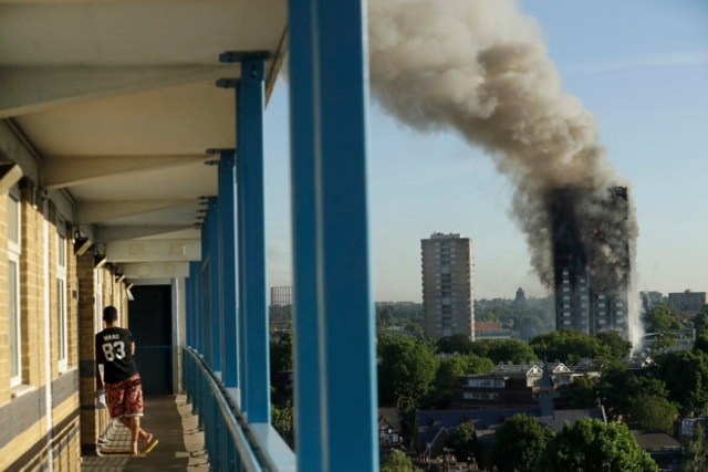 Cột khói bốc lên từ tòa nhà Grenfell Tower sáng 14/6. Ảnh: AP.