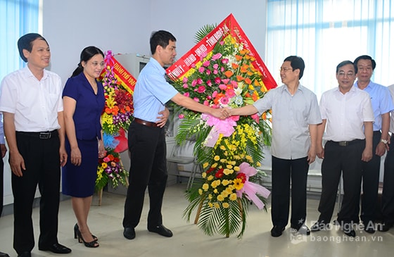 Đồng chí Nguyễn Xuân Sơn tặng hoa chúc mừng đại diện Thường trú Báo Nhân dân tại Nghệ An. Ảnh: Thành Duy