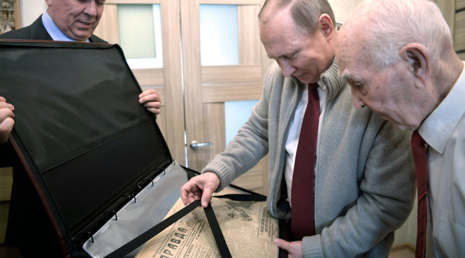 Tổng thống Putin (giữa) tặng quà cho chỉ huy cũ (phải) nhân ngày sinh nhật thứ 90 là tờ báo Pravda ấn bản cách đây 90 năm - Ảnh: Twitter