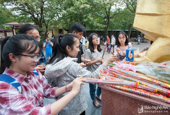 Sau khi hoàn thành thủ tục dự thi, nhiều em học sinh thắp hương trước tượng cụ Phan Bội Châu tại trường THPT chuyên Phan Bội Châu. Ảnh: Thành Cường