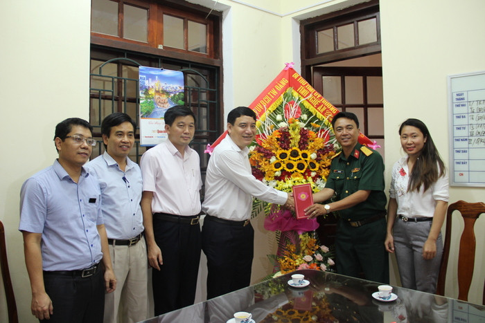 Đồng chí Bí thư Tỉnh ủy Nguyễn Đắc Vinh và đoàn công tác tặng hoa chúc mừng cơ quan Thường trú Báo Quân đội Nhân dân. Ảnh: H.T