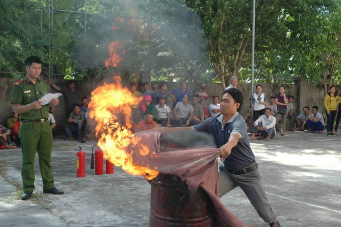 Các học viên thực hành dập cháy bằng chăn nhúng nước. Ảnh: Mai Giang