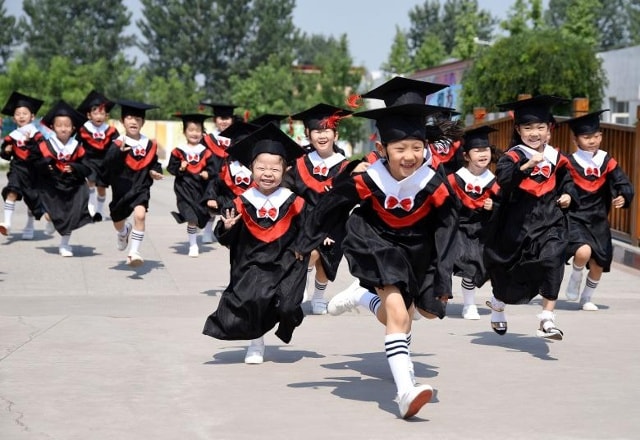 Trẻ em trong áo choàng và ván ghép với nụ cười trong buổi lễ tốt nghiệp mẫu giáo của họ tại một trường mẫu giáo ở Hàm Đan, tỉnh Hà Bắc, Trung Quốc ngày 20 tháng 6 năm 2017