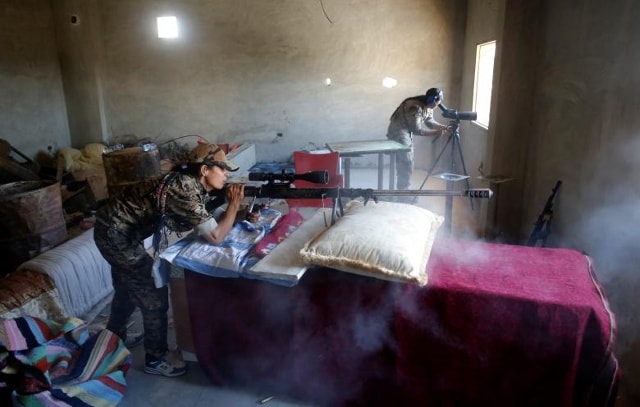 Một nữ chiến binh người Kurd của Phòng Bảo vệ Nhân dân (YPG) bắn một khẩu súng trường bắn tỉa tầm xa ở các chiến binh Hồi giáo ở Raqqa, Syria ngày 18 tháng 6 năm 2017.
