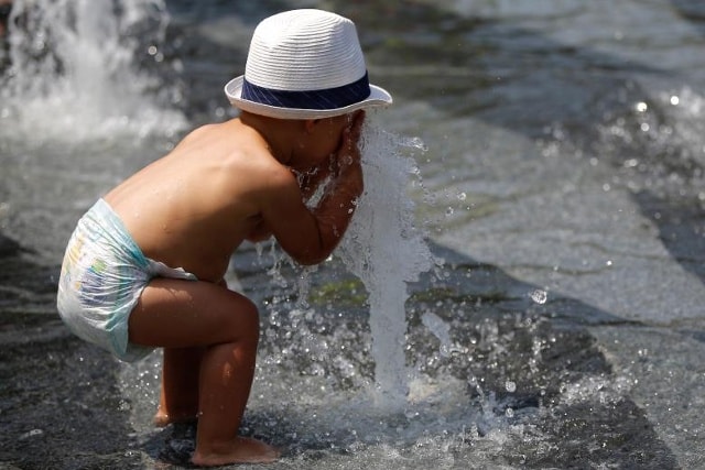 Một đứa trẻ chơi trong một nguồn nước để làm mát từ sức nóng tại Miroir d'Eau, ở Nantes khi nhiệt độ cao bất thường ở Pháp, ngày 20 tháng 6 năm 2017