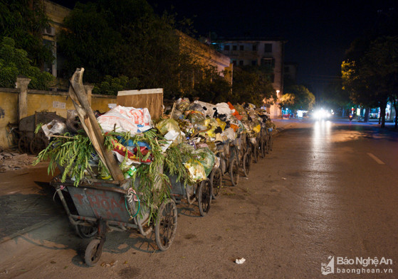 Cứ vào khoảng  7 - 10h tối hàng ngày, trên đường Hồng Bàng (phường Lê Mao)  đoạn đối diện các nhà số 16; 18; 20 luôn có từ 3 đến 5 xe thu gom rác tập kết thành dãy dài. Tất cả đều chất đầy các loại rác thải sinh hoạt bốc mùi xú uế nồng nặc. Ảnh: Thành Cường