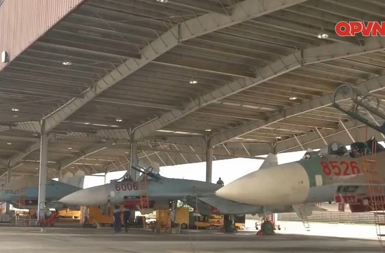 Trong ảnh là nhà để máy bay của Trung đoàn 925 với chiếc tiêm kích Su-27UBK sơn màu cỏ mía sau khi được đại tu thành công tại nhà máy A32, ngoài ra còn một số máy bay vẫn giữ màu sơn truyền thống. Nguồn ảnh: Kênh QPVN