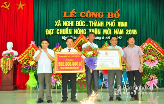 Đồng chí Võ Viết Thanh - Bí thư Thành ủy Vinh và đồng chí Trần Văn Mão trao Bằng công nhận đạt chuẩn NTM và phần thưởng về đích trị giá 500 triệu đồng cho lãnh đạo xã Nghi Đức