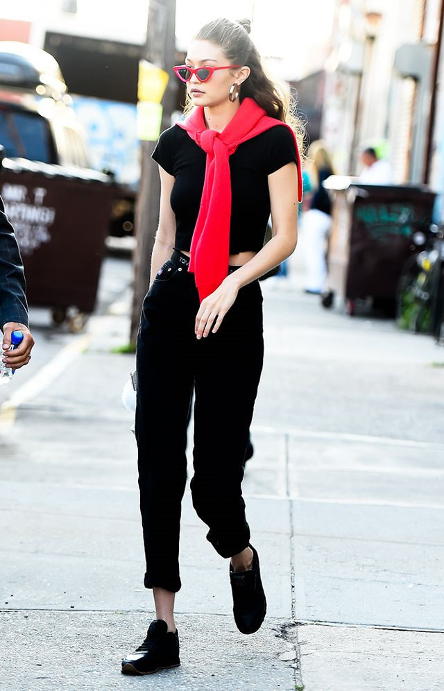 Vẫn chọn phong cách năng động quen thuộc, Gigi Hadid diện set đồ đen đơn giản: crop top, quần jeans và sneaker. Áo len buộc cổ và kính râm viền đỏ tạo điểm nhấn cho cả trang phục.