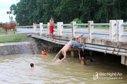 Tắm dưới cầu và nhào lộn trên cầu xuống kênh tiềm ẩn nguy cơ đuối nước, va đập lớn. Ảnh: Huy Thư