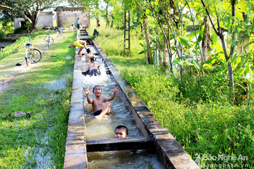  Những con mương bê tông ở xã Hưng Mỹ (Hưng Nguyên) cũng là nơi tắm mát “lý tưởng” của trẻ em trong làng. Tuy mương nhỏ hẹp, nhưng lượng nước chảy mạnh cũng tiềm ẩn nguy cơ đuối nước khi các em lơ là, chủ quan. Ảnh: Huy Thư