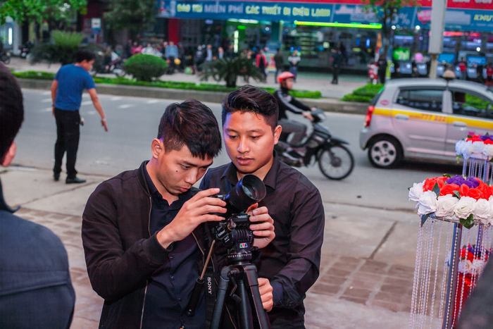 Trịnh Hữu Thắng (trái) đang được một thành viên trong đội truyền thông hướng dẫn kỹ năng quay phim sự kiện. Ảnh: Chu Thanh