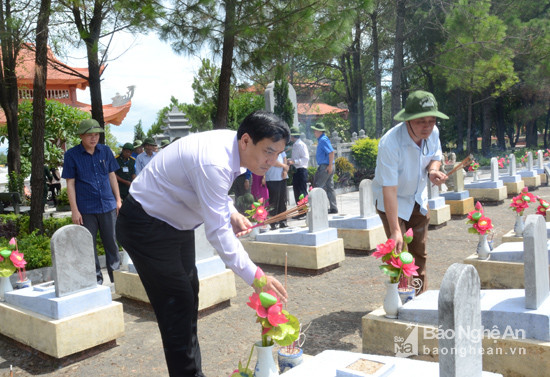 Đồng chí Nguyễn Đắc Vinh cùng các đại biểu dâng hương tại các phần mộ liệt sĩ. Ảnh: Thanh Sơn