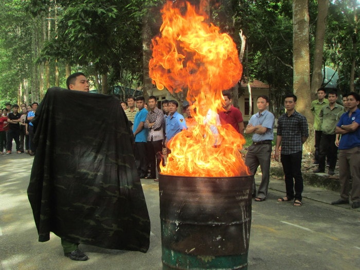 Học viên thực hành dập tắt đám cháy bằng chăn. Ảnh: Bá Hậu