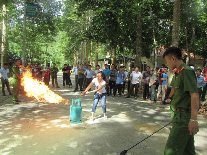 Học viên thực hành dập tắt bình gas bằng khăn tay thấm nước. Ảnh: Bá Hậu