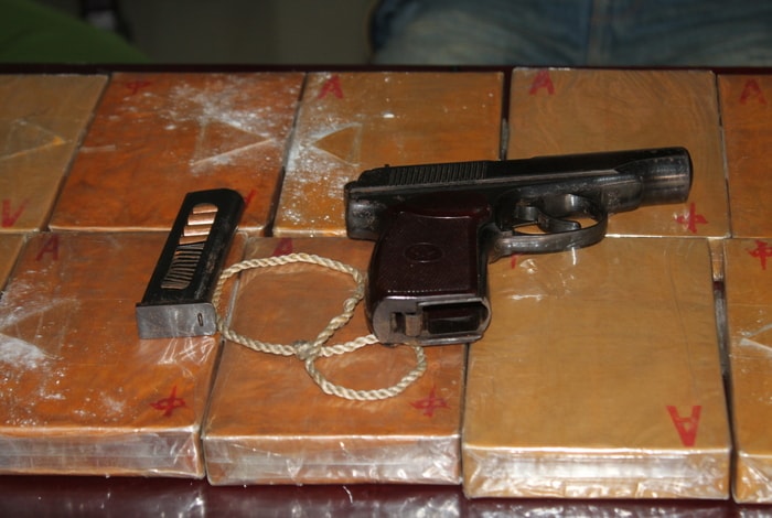 Số heroin và khẩu súng đối tượng mang theo. Ảnh: Anh Tuấn