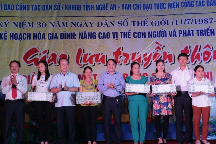 Lãnh đạo các đơn vị tặng quà cho các gia đình thực hiện tốt chính sách dân số của huyện Hưng Nguyên. Ảnh: Mỹ Hà