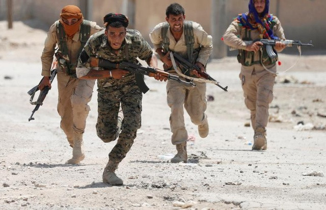 Những chiến binh người Kurd của Phòng Bảo vệ Nhân dân (YPG) chạy qua một con đường ở Raqqa, Syria ngày 03 tháng 7 năm 2017